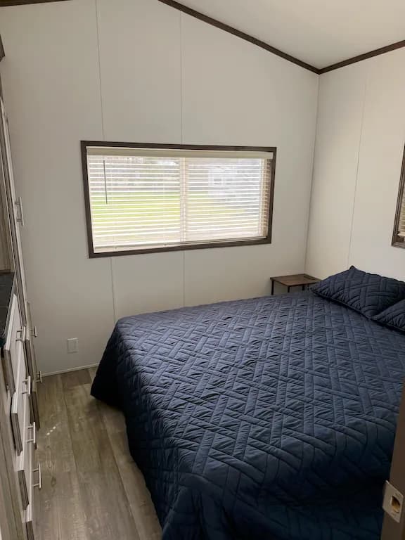 Cozy park model bedroom with queen bed and natural light