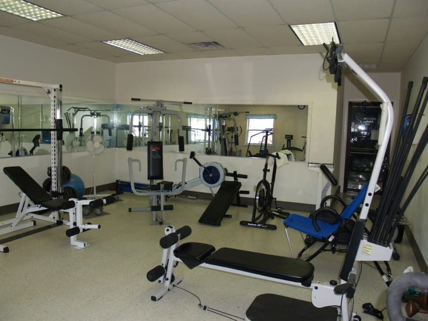 Fitness room with weight machines, cardio equipment, and mirrors
