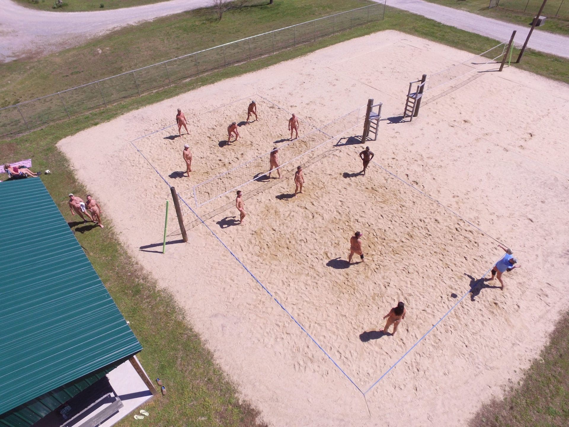 Aerial view of sand volleyball court with players enjoying a game
