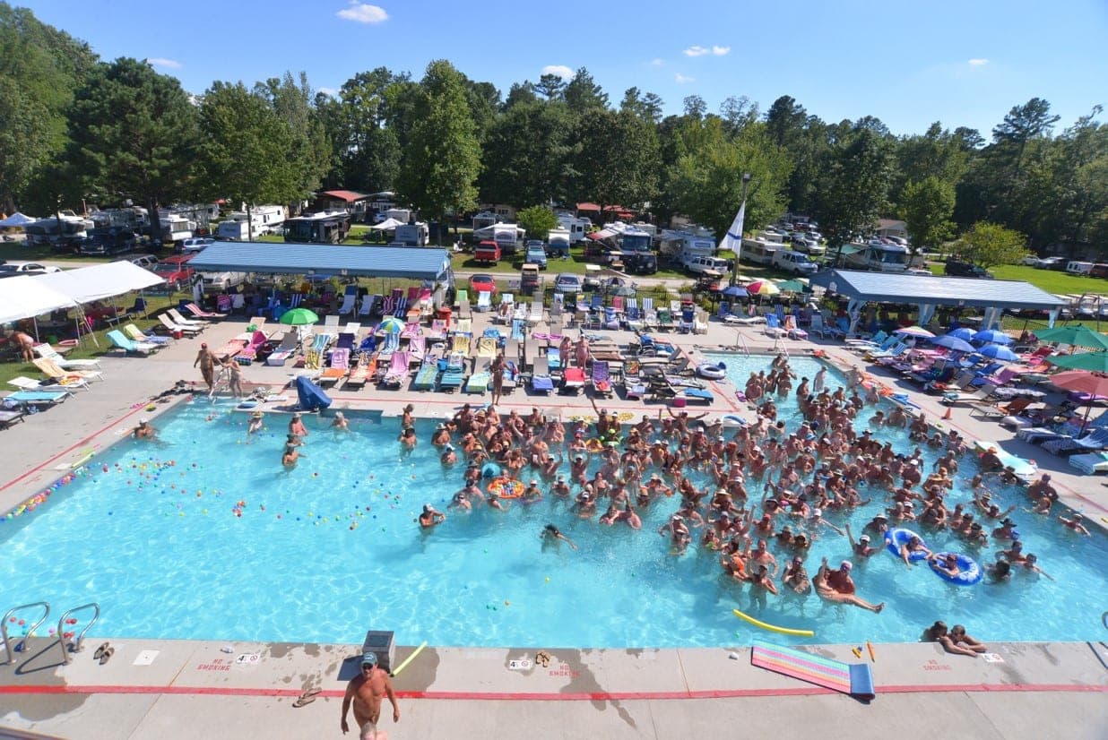 Aerial view of the outdoor Olympic-size pool filled with guests enjoying a sunny day